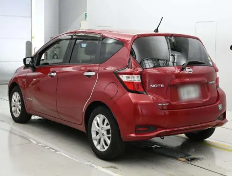 Red Nissan Note e-Power 2017 hatchback, interior dashboard view.