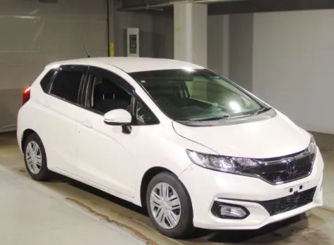 White Honda Fit 2018 hatchback, side profile, showing compact design.