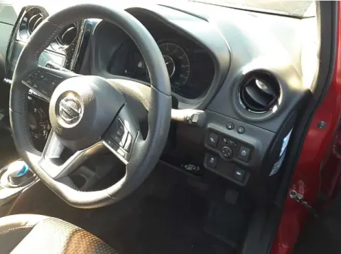 Red Nissan Note e-Power 2017 hatchback, front seats and steering wheel.