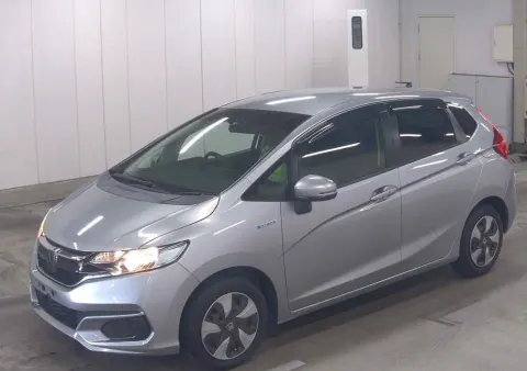 Honda Fit Hybrid 2018 silver hatchback, side view, showing compact design, in transit from Japan.
