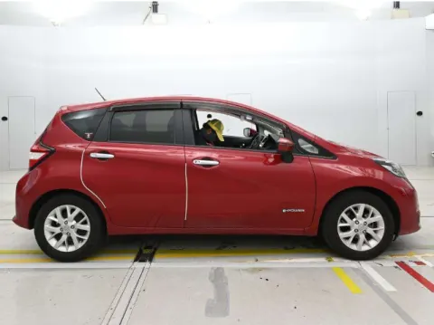 Red Nissan Note e-Power 2017 hatchback, side profile, showing its body lines.