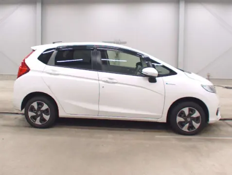 Side profile of a white 2018 Honda Fit Hybrid with clean lines.