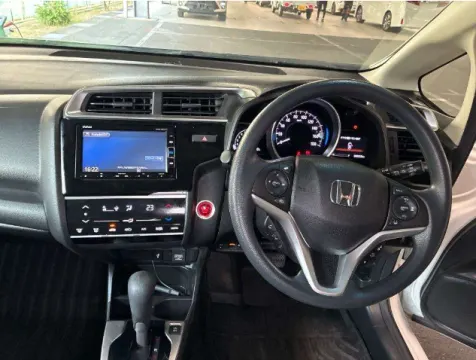 White Honda Fit 2018 hatchback, front three-quarter view, at dealership.