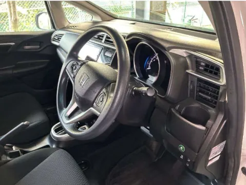 Interior of a white Honda Fit 2018, showing dashboard and controls.