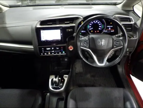 Side profile of a red Honda Fit Hybrid 2018, showing hatchback design, at Car Collection in Musina.